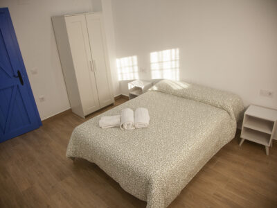 Dormitorio principal con cama de matrimonio y decoración manchega en apartamento de Puerto Lápice.