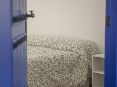 Vistas de habitación rústica desde puerta azul manchega en hostal de Puerto Lápice.