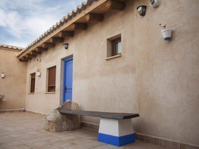 Fachada y patio de apartamentos rurales en Puerto Lápice con arquitectura manchega y puertas azules.
